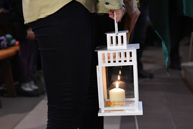 Na snímke skautka drží lampáš s betlehemským svetlom 