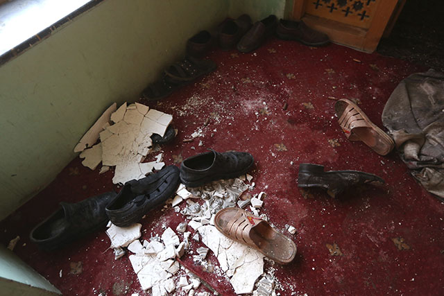 Topánky obetí sú na koberci v dome afganského poslanca Míra Valího po útoku bojovníkov hnutia Taliban na dom afganského poslanca v hlavnom meste Kábul