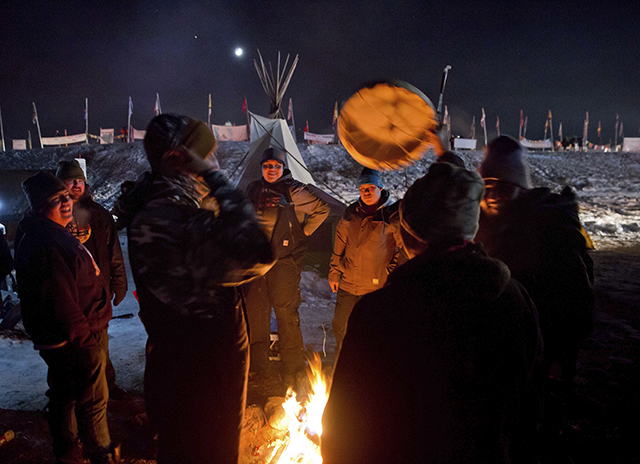 Pôvodní americkí obyvatelia  bubnujú a spievajú počas osláv v indiánskom tábore Oceti Sakowin v Cannon