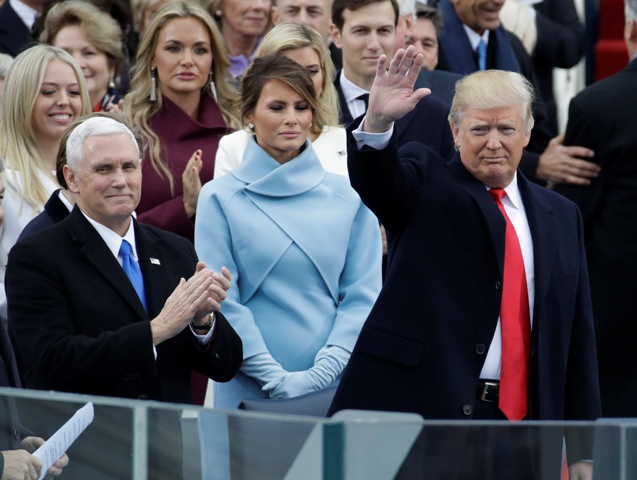 Budúci americký prezident Donald Trump máva vedľa svojej manželky Melanie Trumpvej, vľavo budúci viceprezident Mike Pence  pred inauguráciou v centre Washingtonu 20. januára 2017