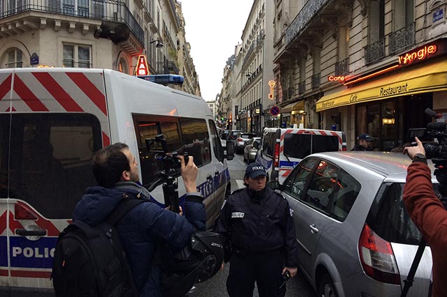 Na snímke policajný dôstojník uzatvára ulicu, kde ozbrojení policajti prehliadajú domy v okolí  múzea Louvre v Paríži 