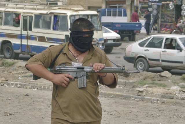 Na snímke hliadkujúci maskovaný ozbrojenec